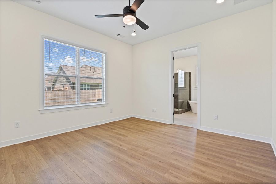 Spacious room featuring light wood-finish flooring, a ceiling fan with integrated lighting, and recessed ceiling lights Spacious room featuring light wood-finish flooring, a ceiling fan with integrated lighting, and recessed ceiling lights