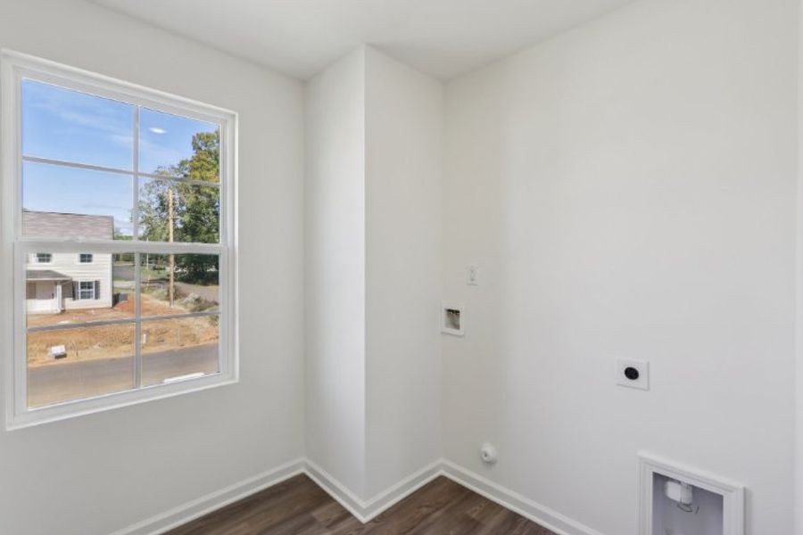 A room with a window and a wood floor.