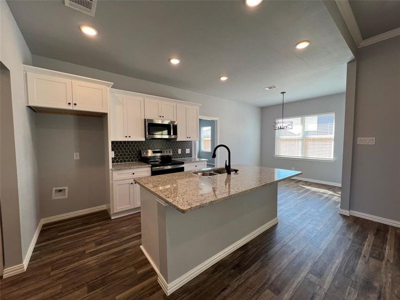 Kitchen featuring sink, white cabinetry, and stainless steel appliances