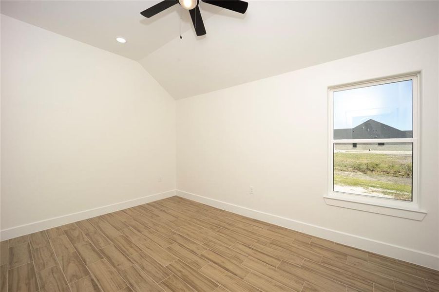 Unfurnished room with lofted ceiling, recessed lighting, wood finish floors, and ceiling fan