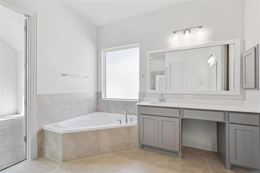 Bathroom featuring vanity, a garden tub, light tile patterned floors, and a shower stall