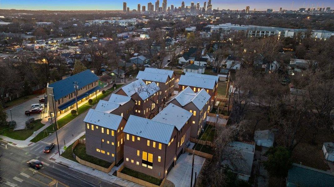An aerial perspective reveals a vibrant community with modern residences and a striking city skyline.