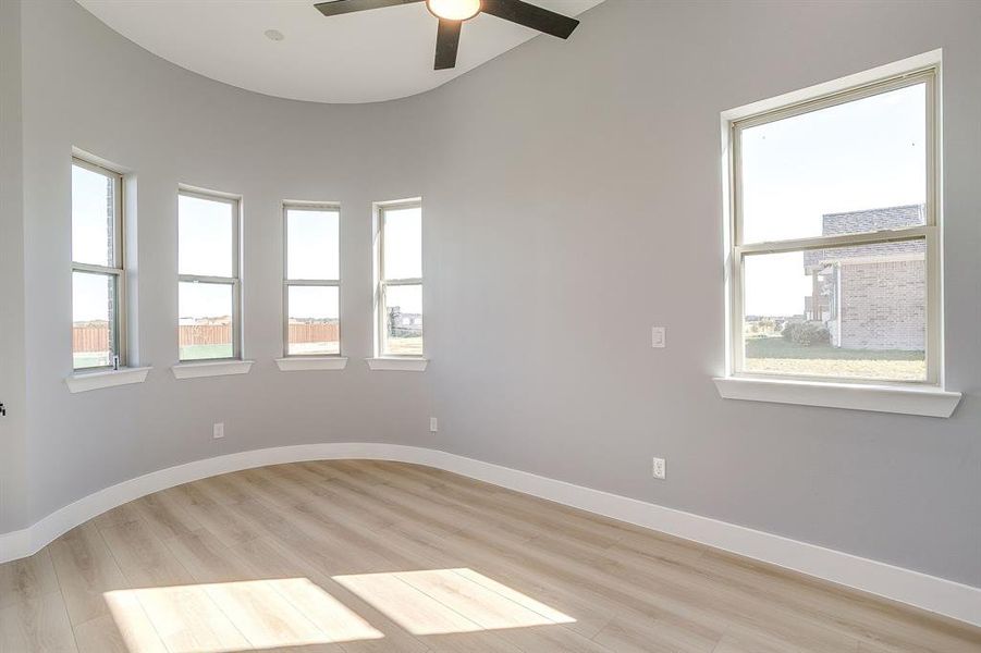 Empty room with light wood-style floors and a ceiling fan