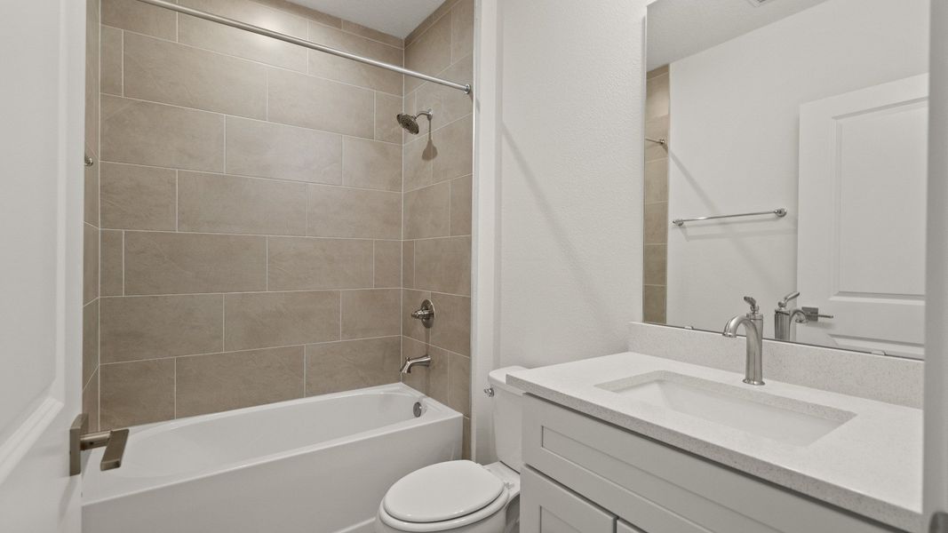 Stylish guest bathroom with sleek vanity, contemporary tilework, and a clean, inviting design.