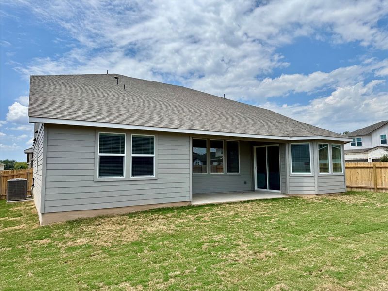 Rear view of property with a patio area and a shingled roof Rear view of property with a patio area and a shingled roof