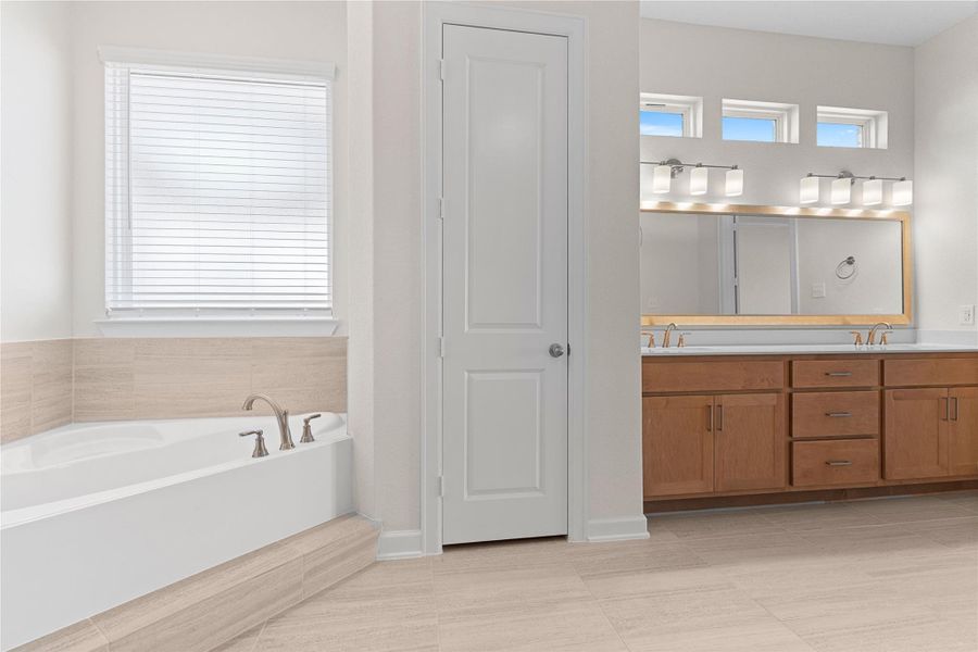 Another angle of the primary bath showcases the soaking tub and generous vanity, enhanced by natural light and tasteful finishes, delivering a calm and comfortable retreat for daily routines.