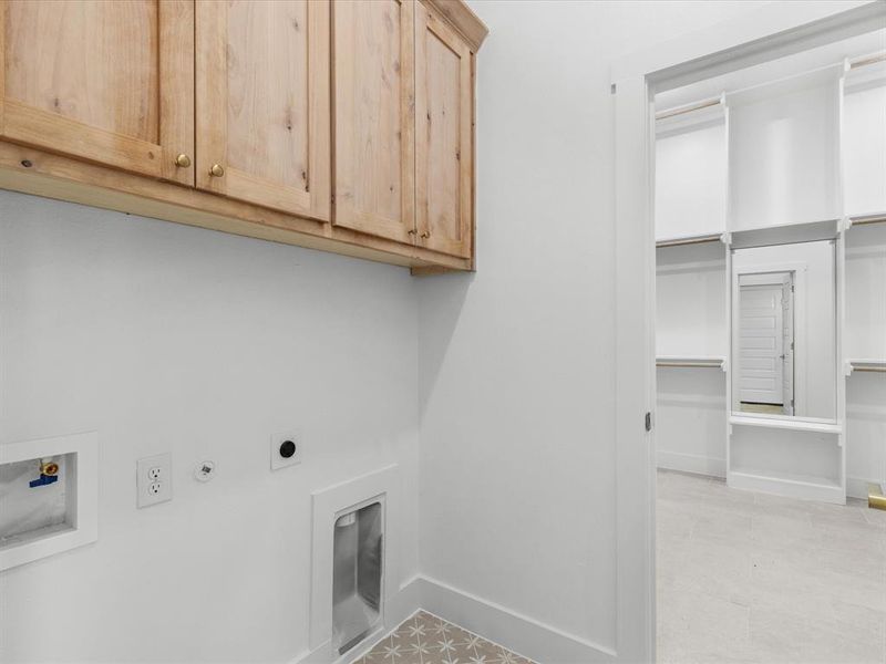 Laundry room featuring hookup for a gas dryer, cabinet space, electric dryer hookup, and washer hookup