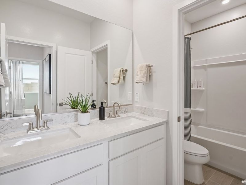 A bathroom with a tub sink and toilet.
