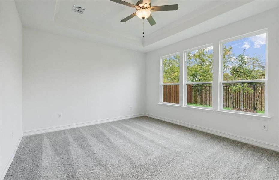 Elegant owner's suite with Tray ceiling and large windows*real home pictured