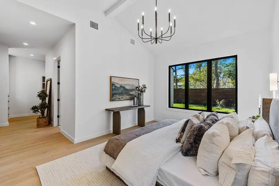 Bedroom featuring light wood-type flooring, a chandelier, beamed ceiling, high vaulted ceiling, and recessed lighting