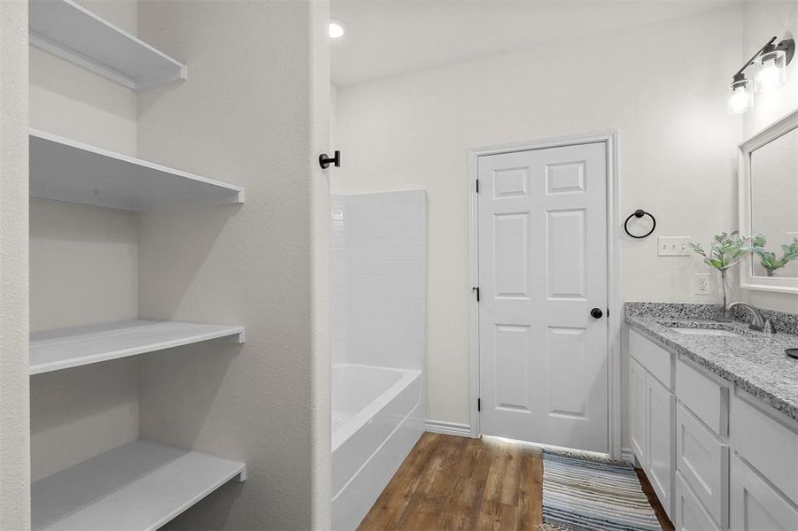 Bathroom featuring shower / tub combination, hardwood / wood-style floors, and vanity