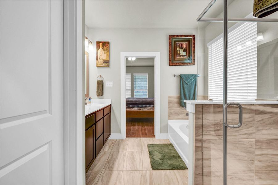 Primary en suite offers double vanities, a large walk in closet and matching tile floors and shower Primary en suite offers double vanities, a large walk in closet and matching tile floors and shower