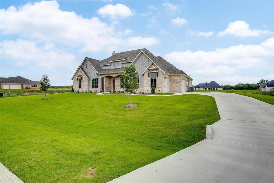 French country style house featuring a front lawn and a garage