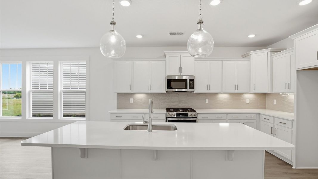 Exceptional culinary space with a striking 9-foot island and eye-catching pendant lights