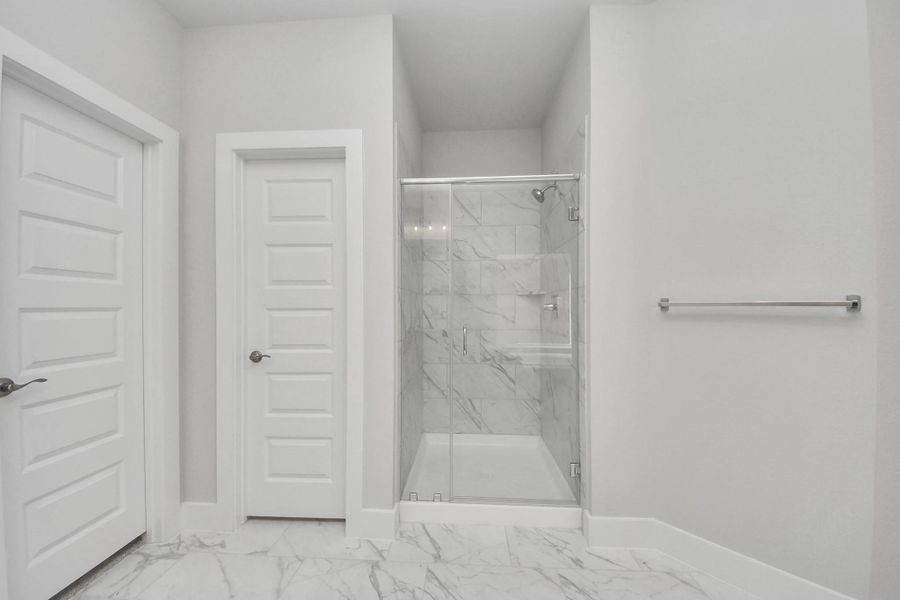 Indulge in a spa-like retreat within the confines of this primary bathroom. Delight in a spacious walk-in shower enveloped in stylish tile surround, unwind in a separate garden tub adorned with custom detailing.