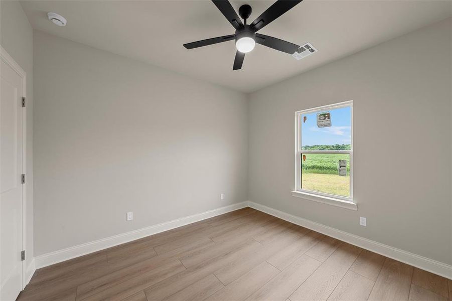 Room featuring wood-finish flooring, a contemporary ceiling fan with integrated lighting, and a single window with white trim