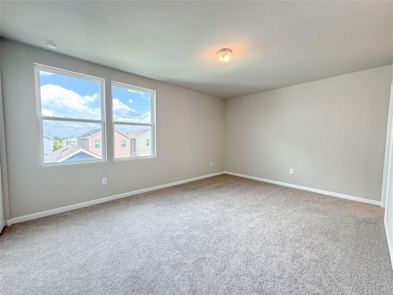 Spacious room featuring neutral carpeting and light-toned walls