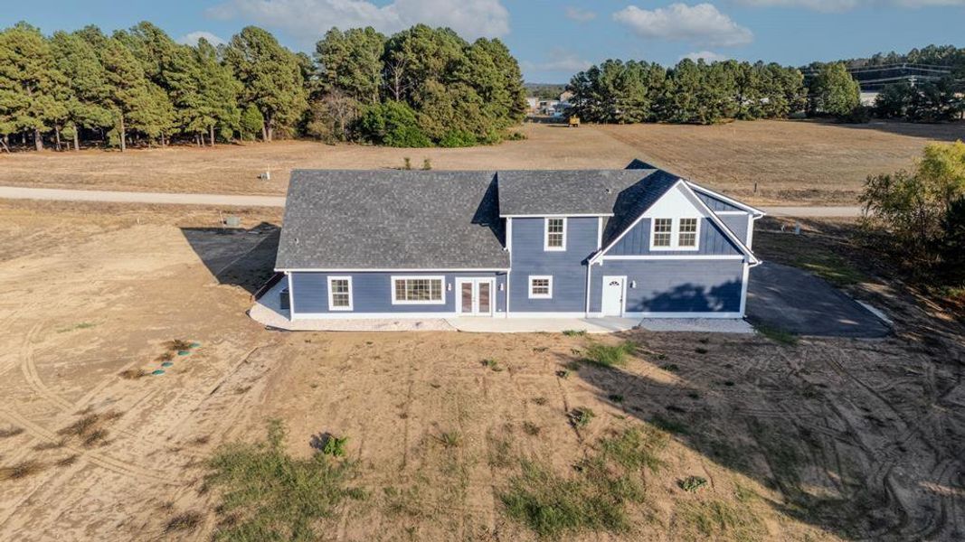 View of front of property with a patio area, board and batten siding, and a shingled roof
