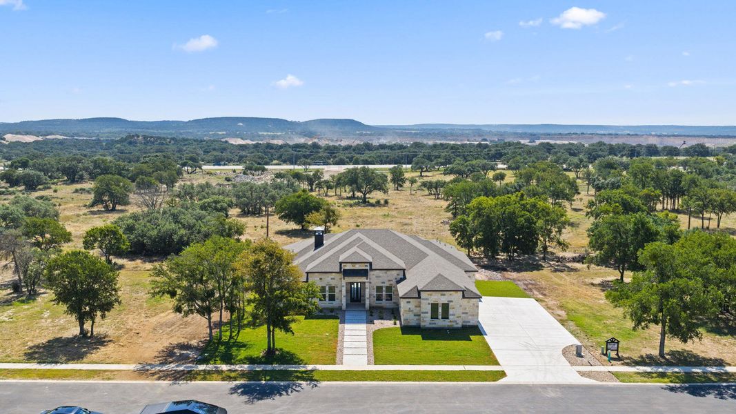 A well-maintained lawn and paved driveway complement this newly built stone residence amidst natural, sprawling landscape. A well-maintained lawn and paved driveway complement this newly built stone residence amidst natural, sprawling landscape.