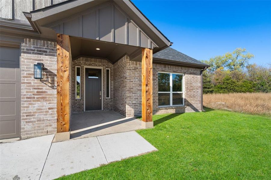 Entrance to property with a lawn and a garage