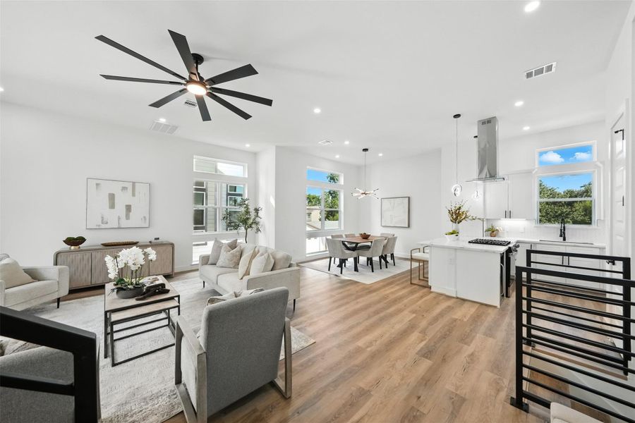 Bright and modern open-concept living space featuring high ceilings, abundant natural light, and designer finishes. This new construction home showcases wide-plank wood flooring, a spacious living and dining area, and a sleek chef’s kitchen with Quartz countertops, waterfall island, gas cooktop, custom cabinetry, and modern pendant lighting. Large windows enhance the airy feel, while the contemporary staircase adds a stylish architectural touch Bright and modern open-concept living space featuring high ceilings, abundant natural light, and designer finishes. This new construction home showcases wide-plank wood flooring, a spacious living and dining area, and a sleek chef’s kitchen with Quartz countertops, waterfall island, gas cooktop, custom cabinetry, and modern pendant lighting. Large windows enhance the airy feel, while the contemporary staircase adds a stylish architectural touch