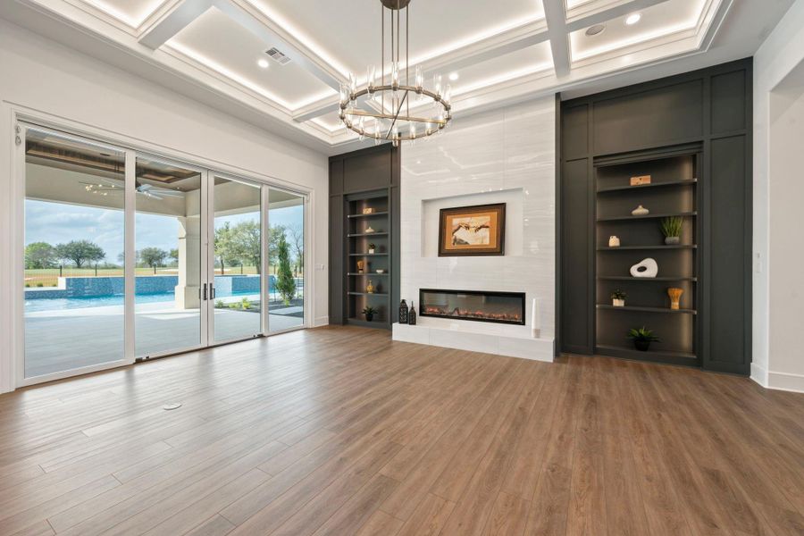 Formal living with attractive linear fireplace, lighted ceiling and built-ins