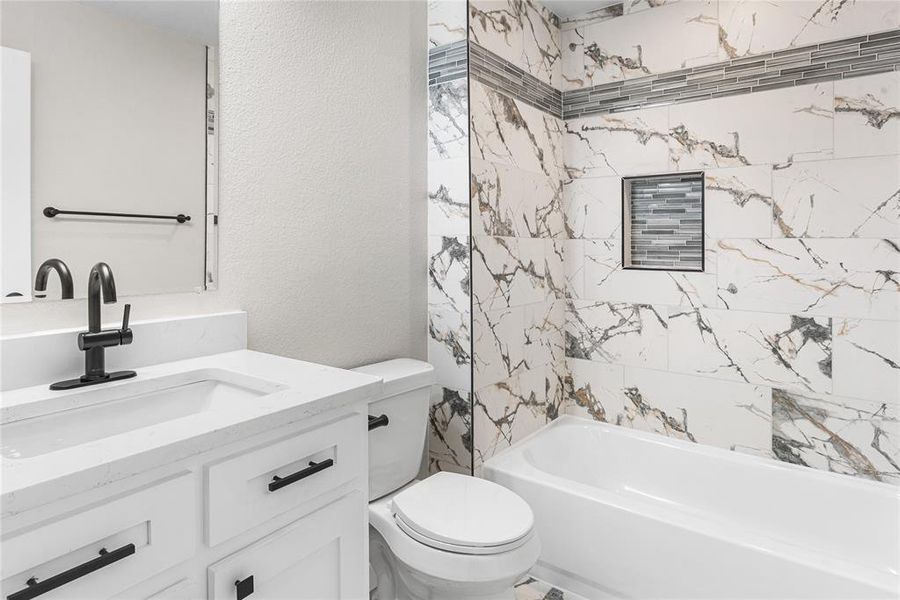 Hall Bathroom featuring a textured wall, vanity, and shower / bathtub combination