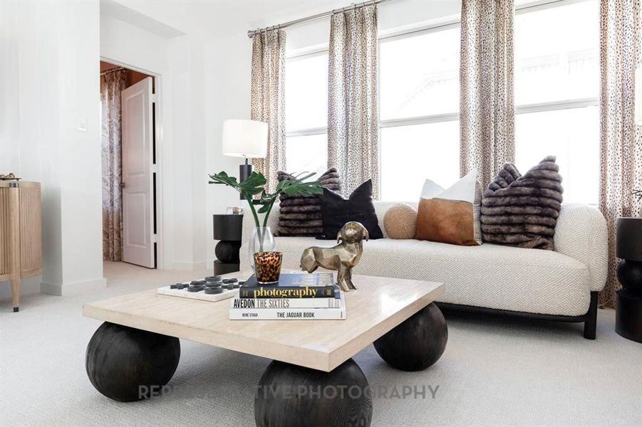 Living area featuring light colored carpet and baseboards