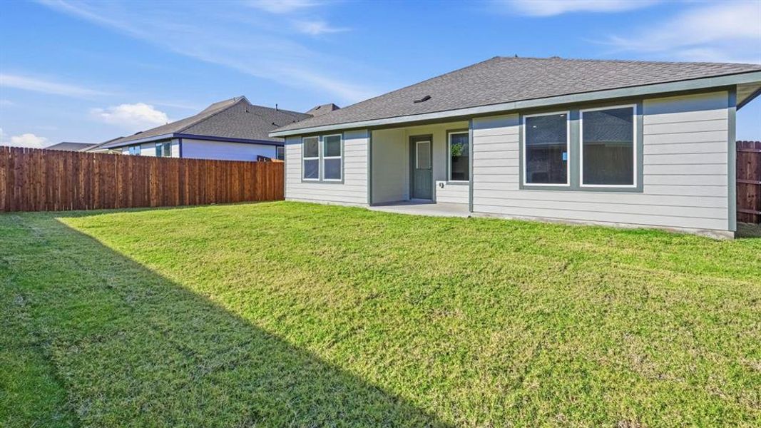 Rear view of house with a patio area, a shingled roof, and a fenced backyard Rear view of house with a patio area, a shingled roof, and a fenced backyard