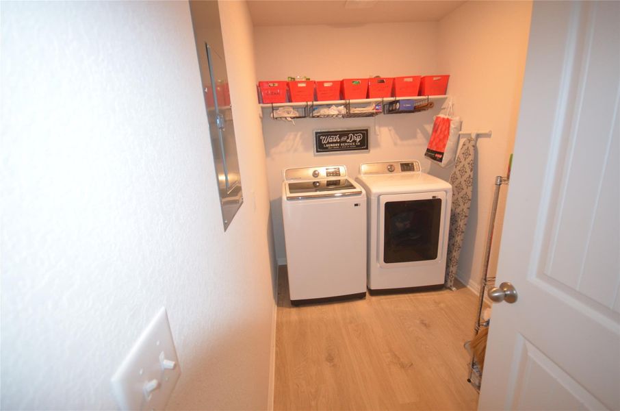 Laundry room featuring independent washer and dryer, light wood-type flooring, and electric panel Laundry room featuring independent washer and dryer, light wood-type flooring, and electric panel