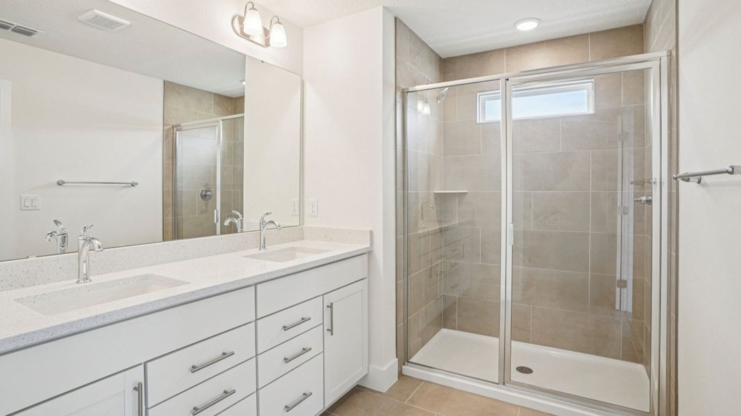 Plumeria Floor Plan primary suite bathroom with dual sinks by DRB Homes in Trailside located in Mount Dora, FL Plumeria Floor Plan primary suite bathroom with dual sinks by DRB Homes in Trailside located in Mount Dora, FL