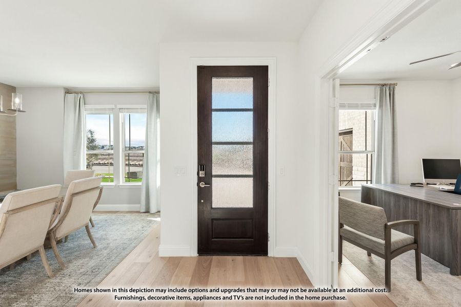 Entryway with dark wood glass-panel front door, light hardwood floors, and adjacent home office and sitting room. Entryway with dark wood glass-panel front door, light hardwood floors, and adjacent home office and sitting room.