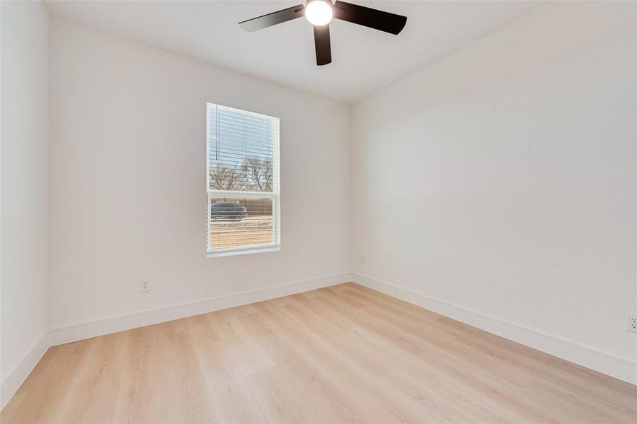 Empty room featuring ceiling fan and light wood-type flooring