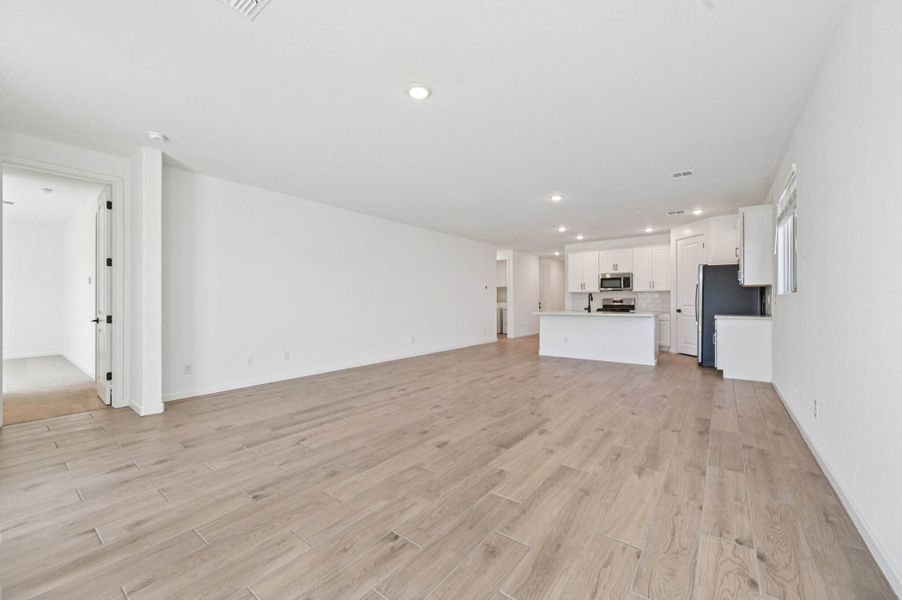 Great room, dining and kitchen. Finishes and options may vary by community.