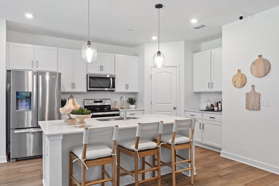 A kitchen with white cabinets.