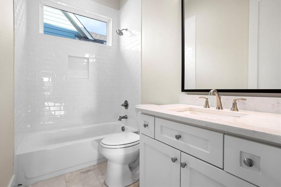 Full bathroom featuring tiled shower / bath, vanity, and toilet