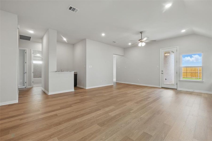 Unfurnished living room with a ceiling fan, recessed lighting, light wood-style floors, baseboards, and vaulted ceiling Unfurnished living room with a ceiling fan, recessed lighting, light wood-style floors, baseboards, and vaulted ceiling