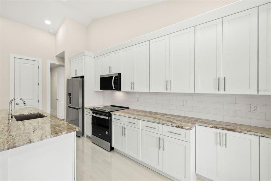 Kitchen - granite countertops, stainless steel appliances, tiled backsplash Kitchen - granite countertops, stainless steel appliances, tiled backsplash