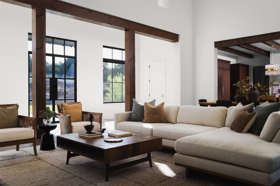 From inside the living room, oversized front-facing windows flood the space with natural light and offer views across the 1.06-acre front lawn. The design centers on the gorgeous custom front door, creating a high-end architectural focal point that immediately connects the home's interior to its private, wooded surroundings