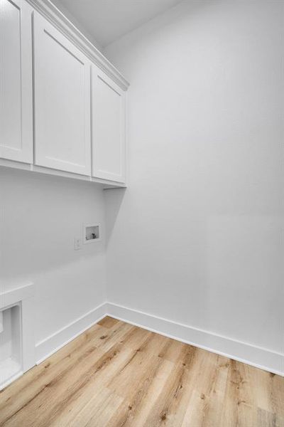 Laundry area featuring cabinets, light wood-type flooring, and washer hookup