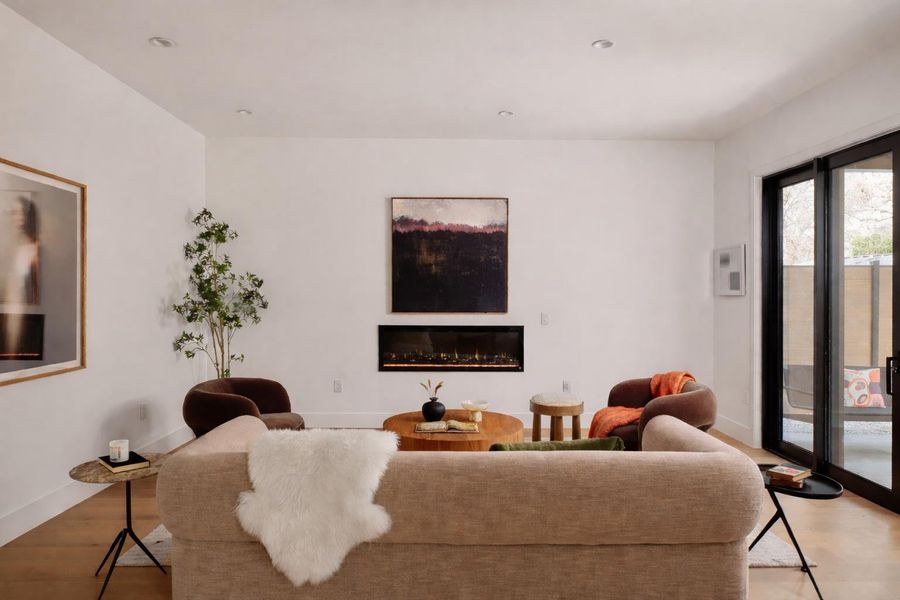 Living room with a glass covered fireplace and wood finished floors