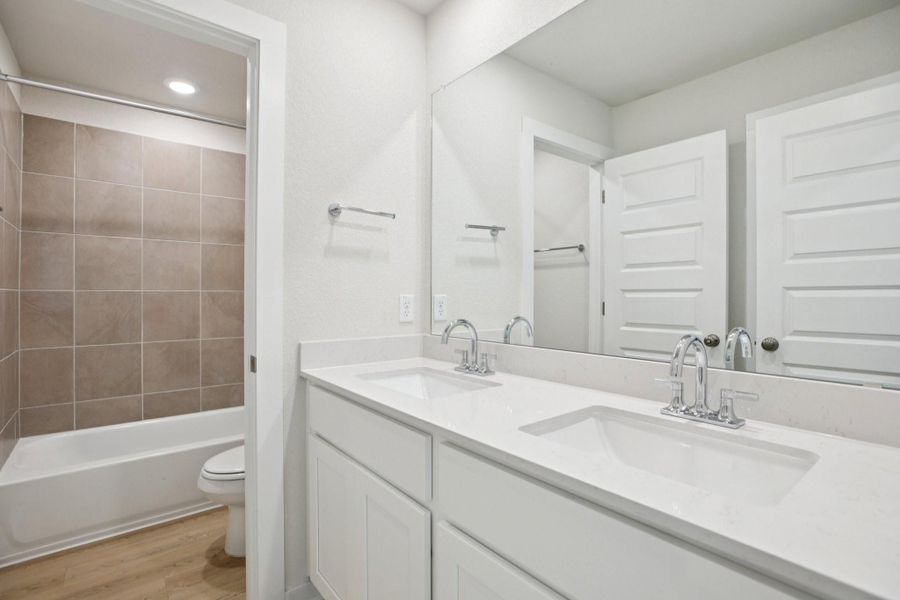 Full bath featuring light wood-style floors, double vanity, shower / bathtub combination, and recessed lighting