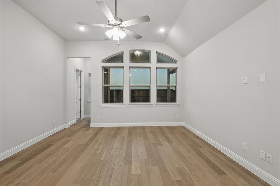 Unfurnished room featuring vaulted ceiling, light wood-style flooring, ceiling fan, and recessed lighting Unfurnished room featuring vaulted ceiling, light wood-style flooring, ceiling fan, and recessed lighting