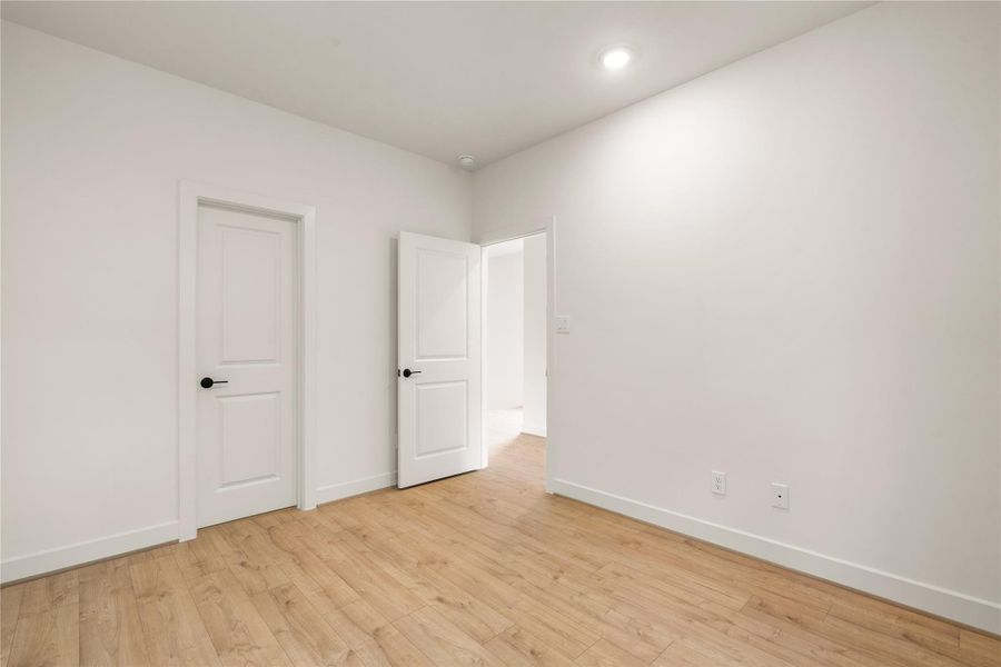 Versatile bedroom space — pre-wired for wall-mounted media, dark door lever accents, and seamless access to private closet storage.