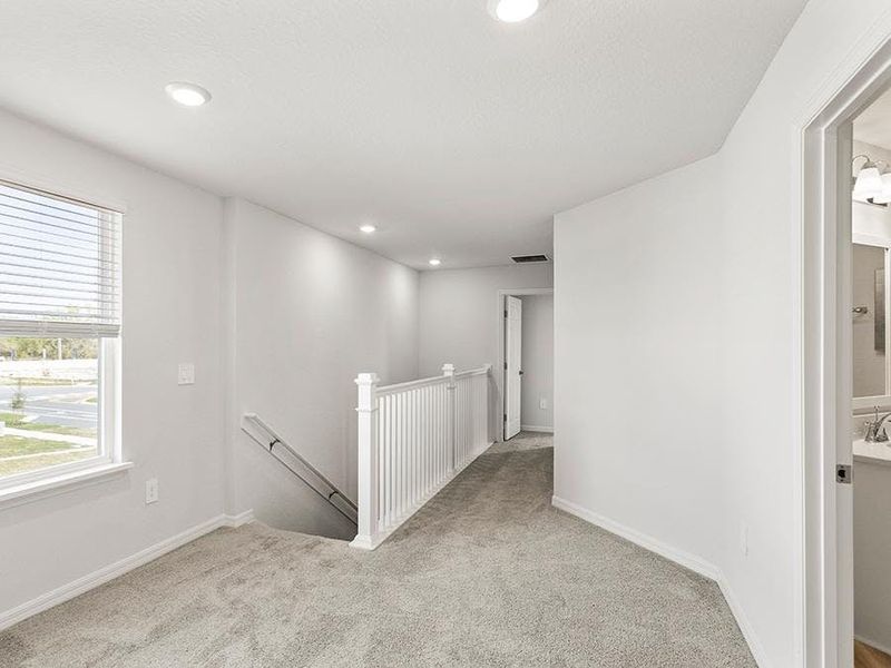 Upstairs, you will find a flex-use loft at the stairway landing - Danyella bungalow by Highland Homes