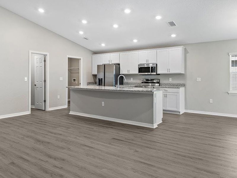 This bright, welcoming home features an open living area with volume ceilings and luxury vinyl plank flooring.