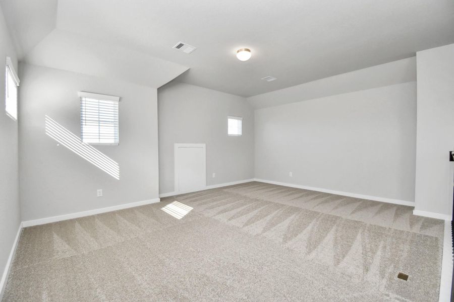 Come upstairs and relish a day of relaxation in this loft area! Ideal as an additional living space or game room, it boasts plush carpeting, high ceilings, custom paint, and windows that flood the area with abundant natural light. Sample photo of completed home with similar floor plan. Actual colors and selections may vary.
