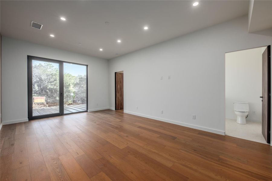 Hardwood floors and an expansive glass door create an inviting, open living space.