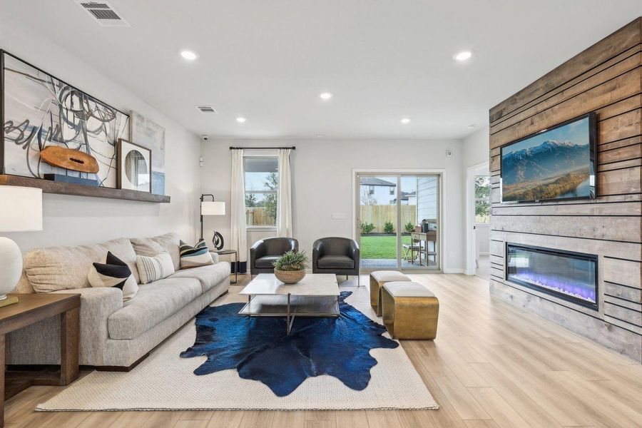 A well-lit gathering space features a captivating linear fireplace and light wood-look flooring. A well-lit gathering space features a captivating linear fireplace and light wood-look flooring.