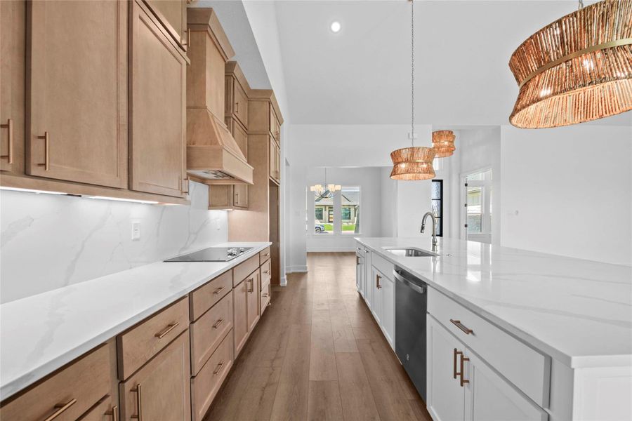 Kitchen featuring pendant lighting, a large island with sink, dark wood-type flooring, light stone counters, and recessed lighting Kitchen featuring pendant lighting, a large island with sink, dark wood-type flooring, light stone counters, and recessed lighting
